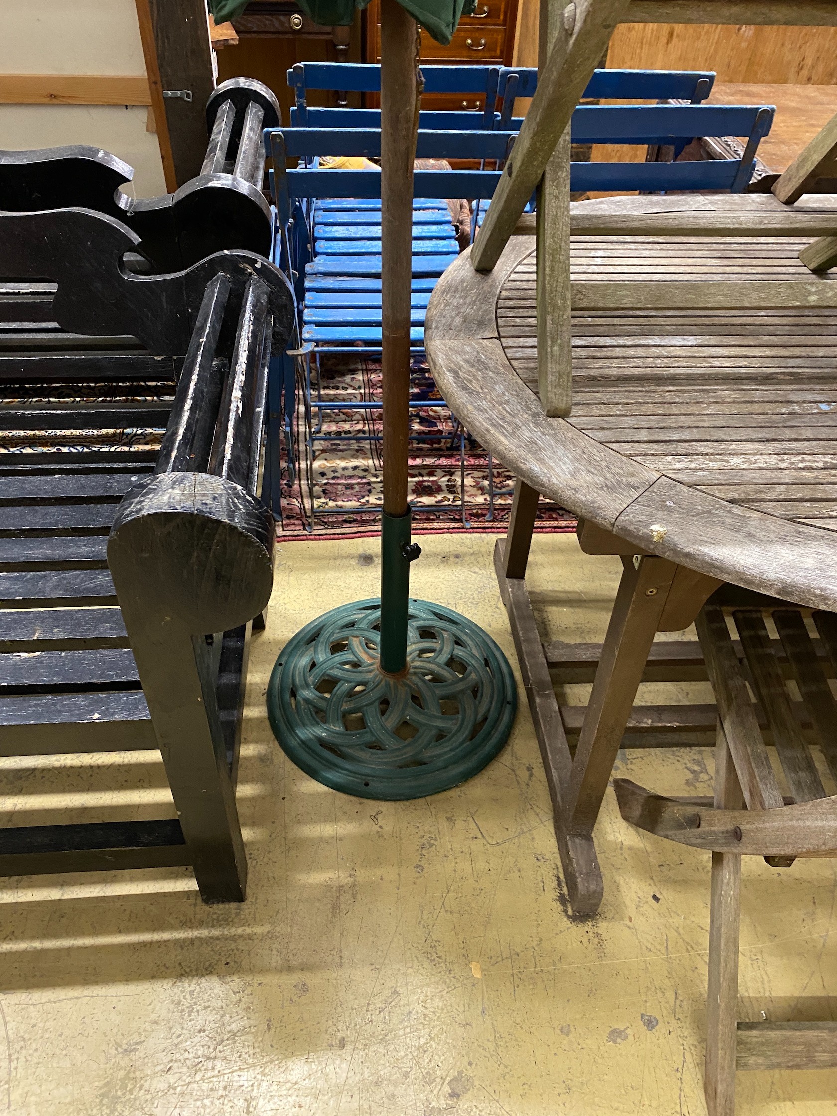 A weathered teak extending garden table, length 170cm, width 100cm, height 74cm parasol with cast metal base and six folding chairs (four and two)